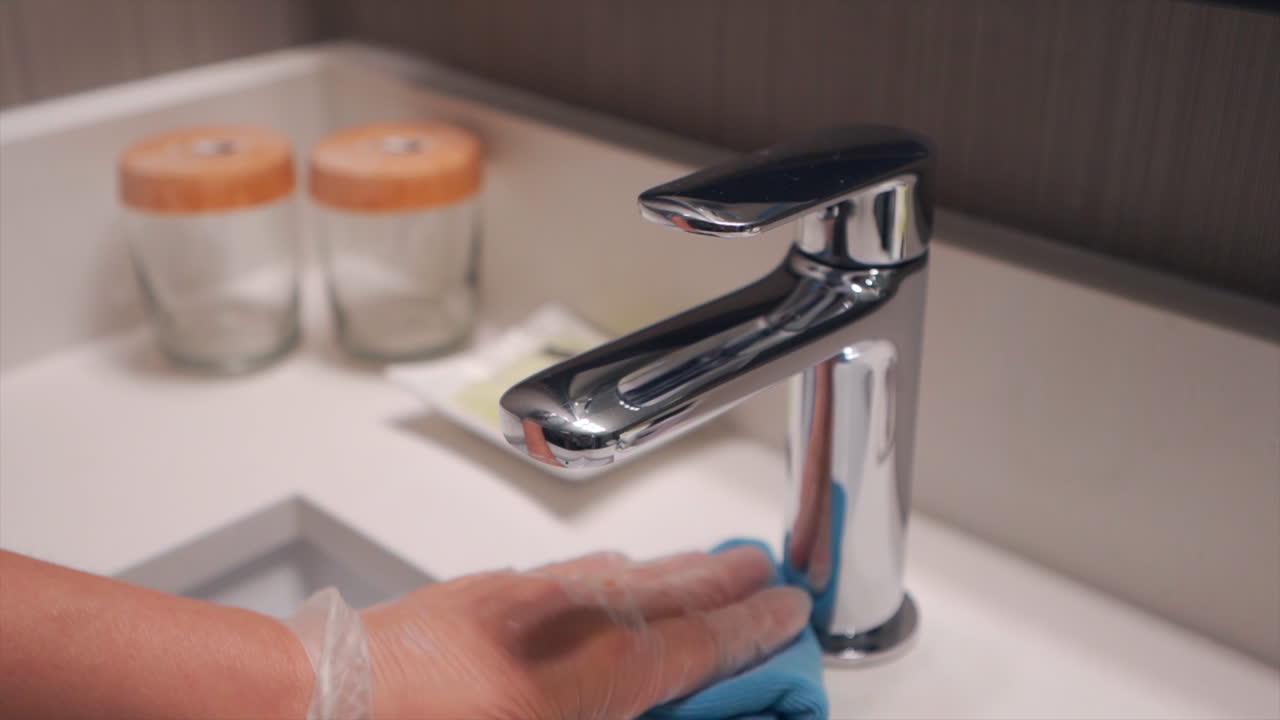La cameriera svolge efficientemente le sue mansioni, riordinando la camera d'hotel con precisione e cura, pulendo e igienizzando ogni cosa