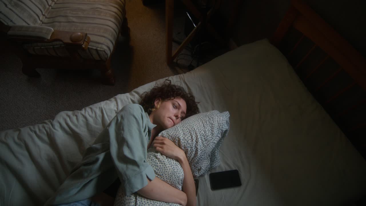 침대에서 잠을 자는 슬픈 여자