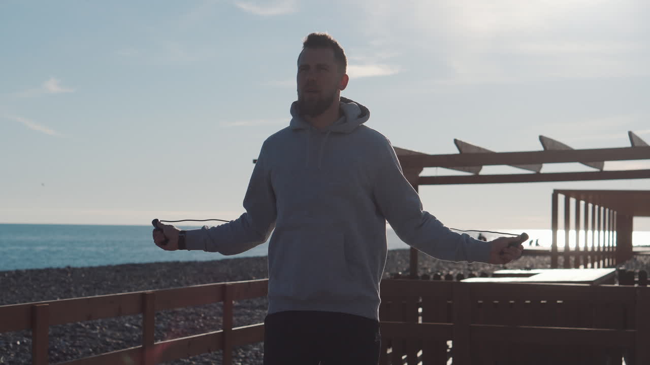 해변에서 로프를 뛰어넘는 남자