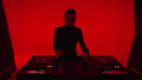 woman djing in a dark studio