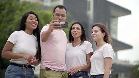 medium shot of smiling people taking selfie on street