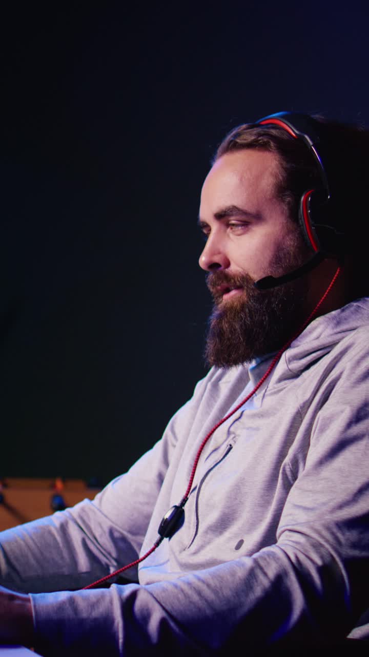 Video verticale. Un uomo si diverte a giocare online a un videogioco FPS competitivo, combattendo robot volanti con i suoi amici