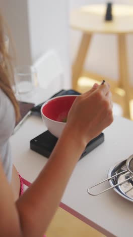 hands preparing a drink, pouring water into a bowl of matcha powder on a kitchen scale