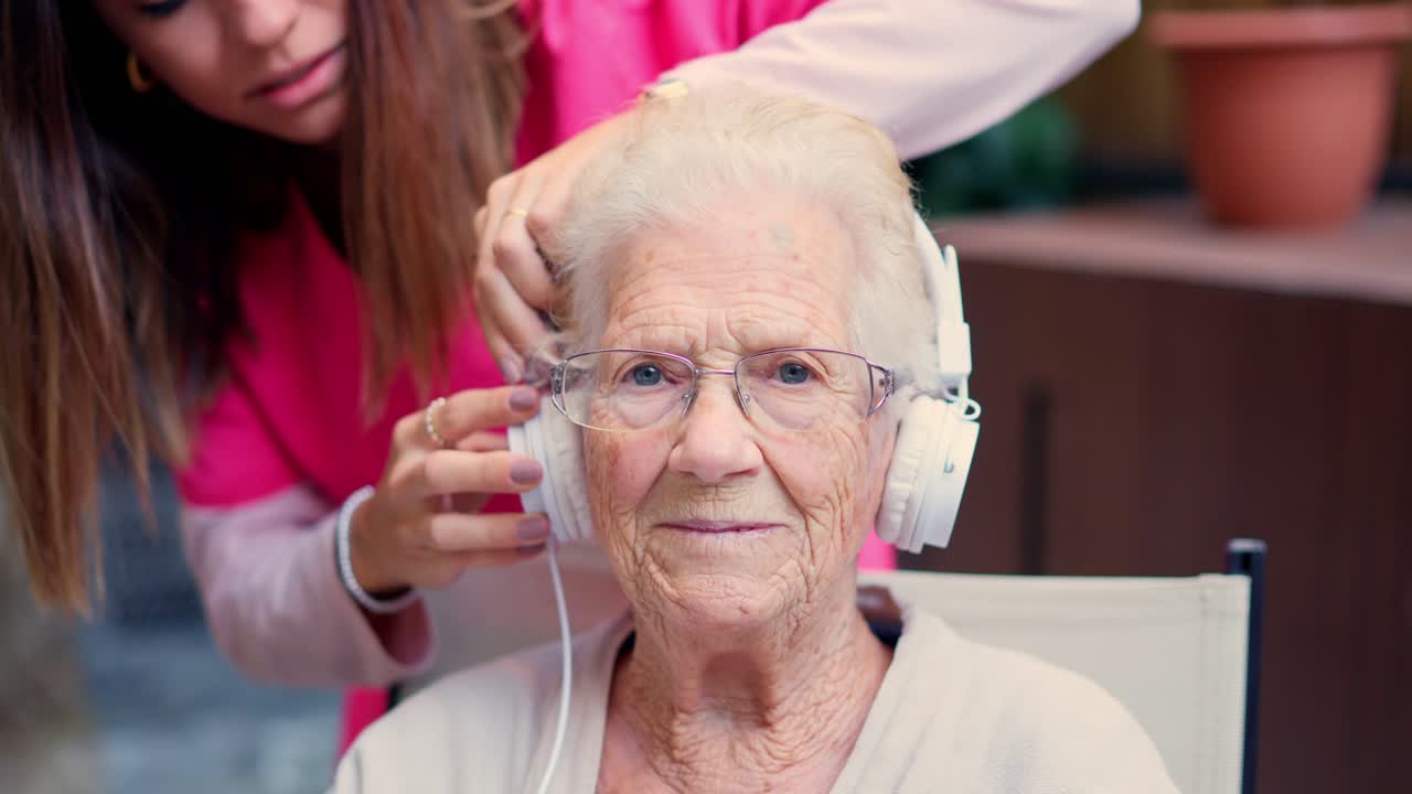 Elderly woman listening to music with caregiver