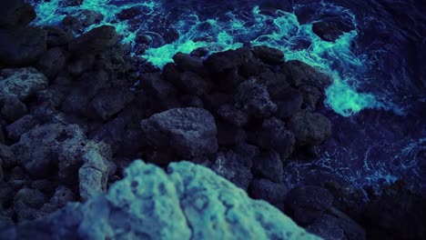 Grabando-Sobre-Rocas-En-La-Costa-De-Francia-Por-La-Noche-Con-Las-Olas-Azules-Rompiendo-Lentamente