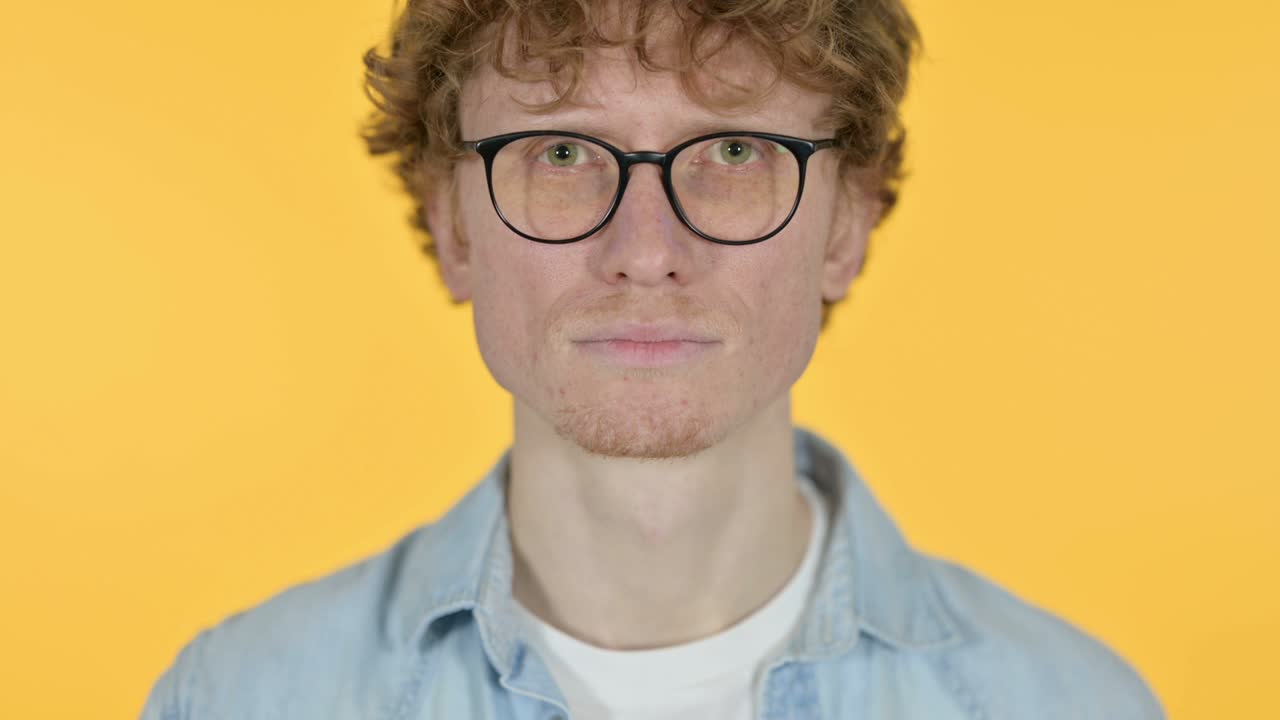 primer plano de un joven pelirrojo sobre un fondo amarillo