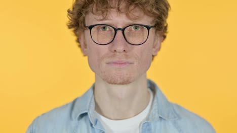 close up of redhead young man on yellow background