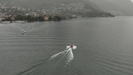 aerial shot of a riva motorboat that crosses lake como on a cloudy day