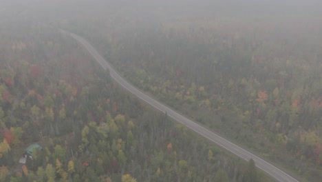 Vista-Aérea-De-La-Carretera-Pavimentada-A-Través-Del-Bosque-Brumoso-De-Otoño.