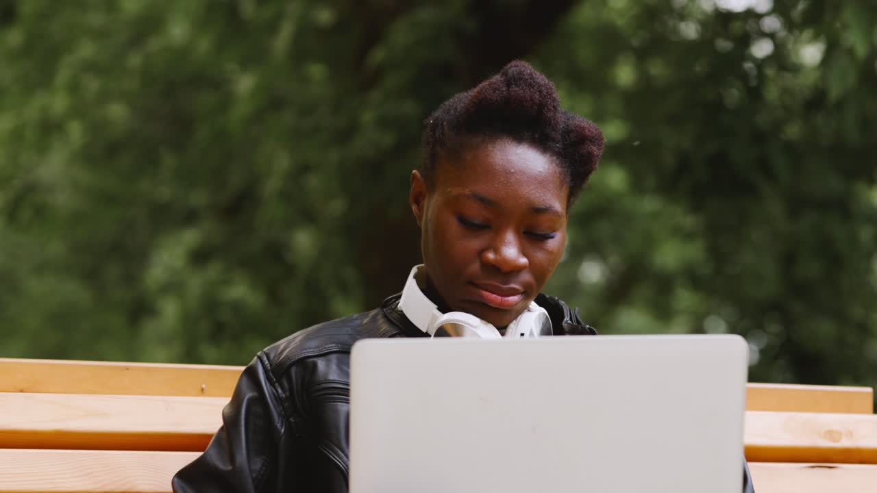 Woman working on a laptop in a park