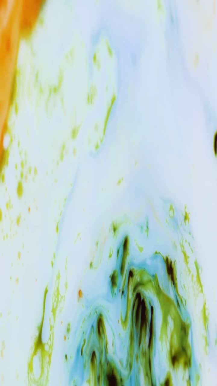 Vista macro di inchiostro colorato che si mescola in un liquido bianco