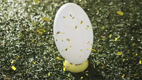 Animation-of-confetti-over-white-rugby-ball-on-grass