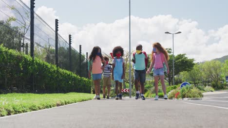 group of kids wearing face masks walking on the road