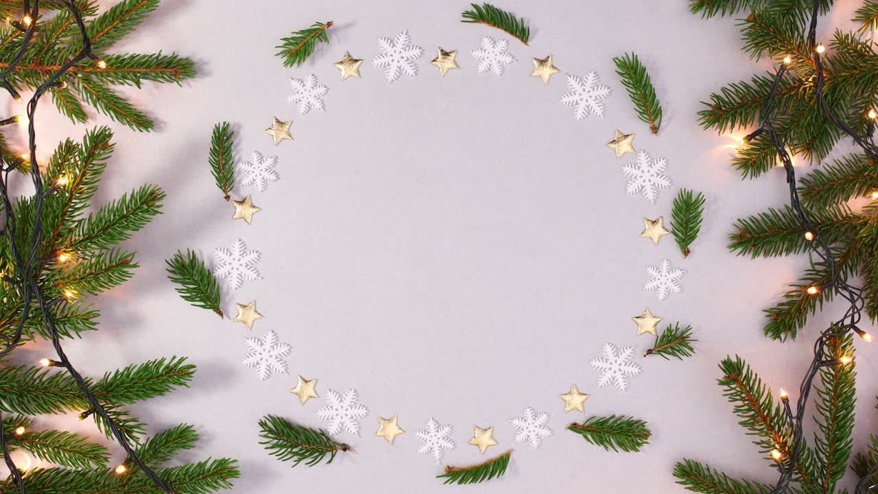 marco redondo con copos de nieve y estrellas para el texto y rama de pino con luces parpadeantes. detener el movimiento