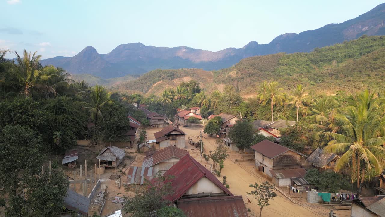 fotografía de un avión no tripulado de una carretera de tierra a través de una pequeña aldea remota en la ciudad montañosa de nong khiaw en laos, sudeste asiático