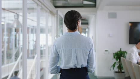 rear view young mixed race business woman walking through office holding documents successful career in corporate workplace 4k