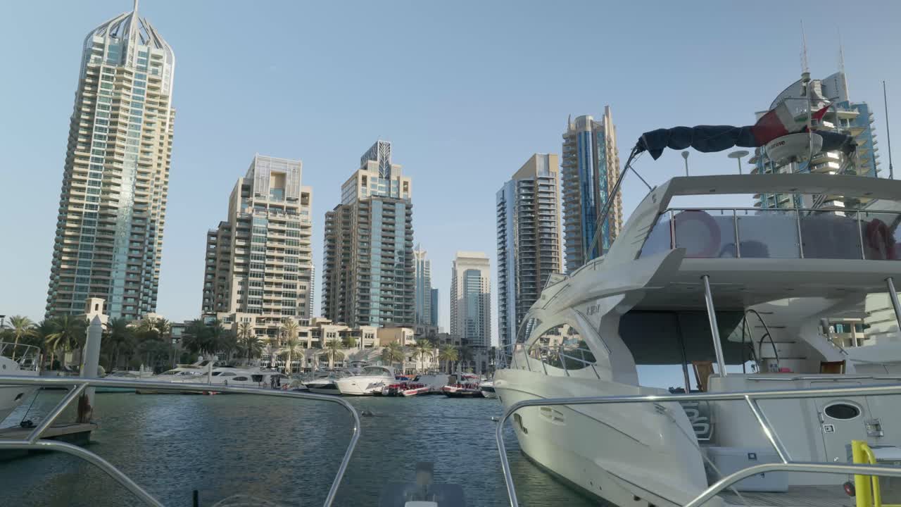 Vue de Dubaï depuis un yacht, en mode POV, au coucher du soleil, avec le yacht qui vire et flotte