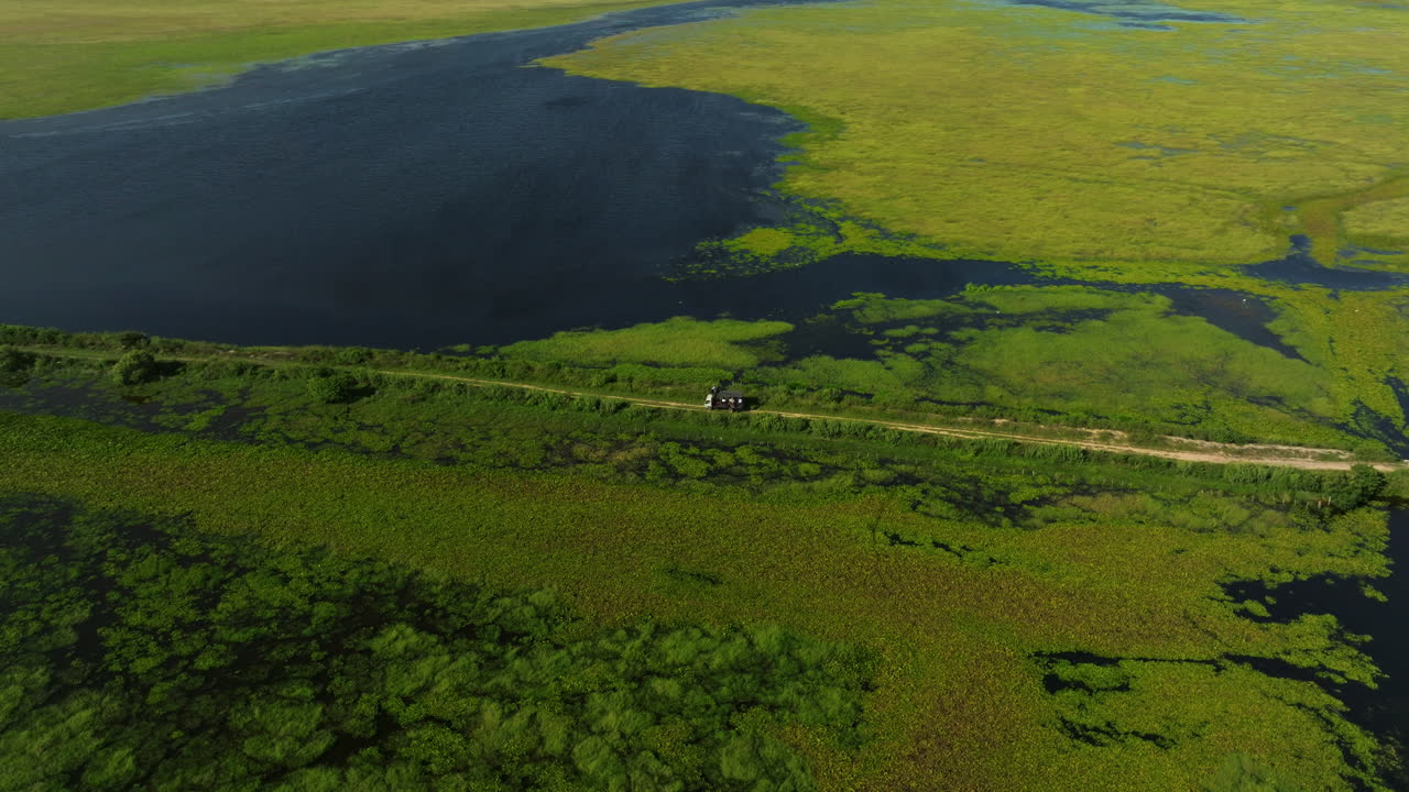 Aerial View of a Swampy Wetland with a Vehicle on a Road