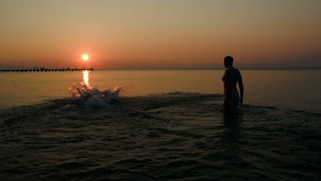 Family-bathing-in-the-sea-at-sunset