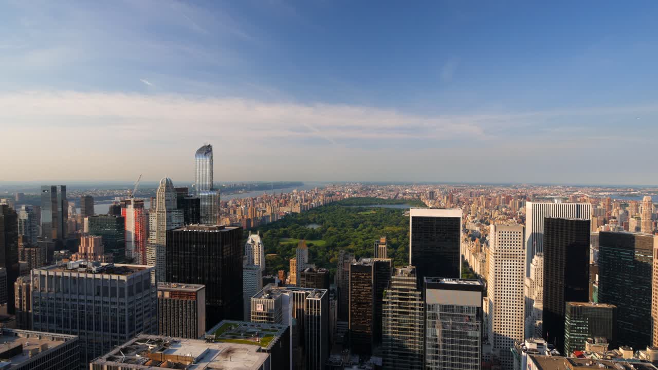 Stunning aerial footage of Central Park nestled among Manhattan's skyscrapers. Captured in perfect daylight, showcasing urban architecture with a serene park oasis below