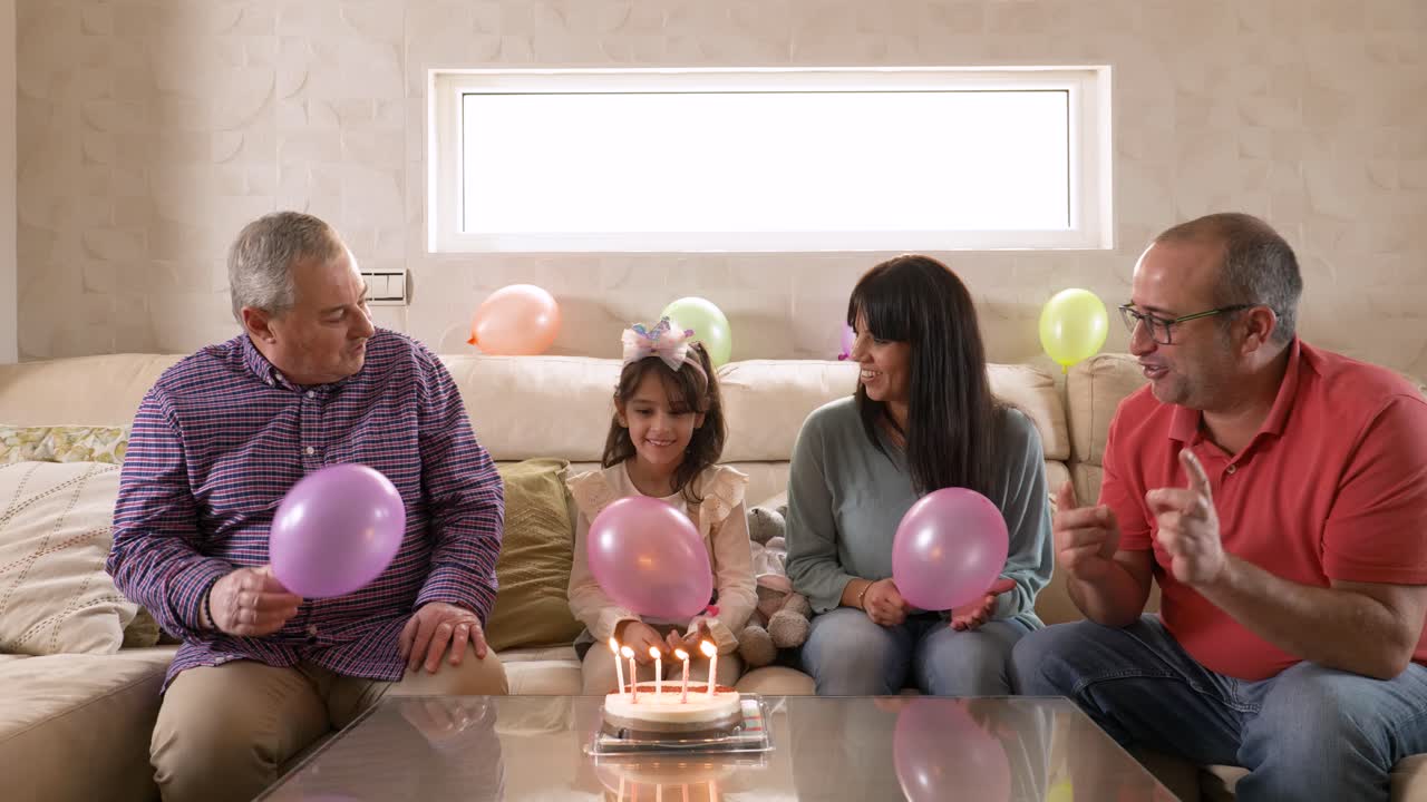 Happy family singing Happy Birthday sitting at home
