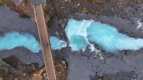 highlight the natural beauty and majesty of the waterfall, turquoise color, and icelandic landscape, waterfall bruararfoss