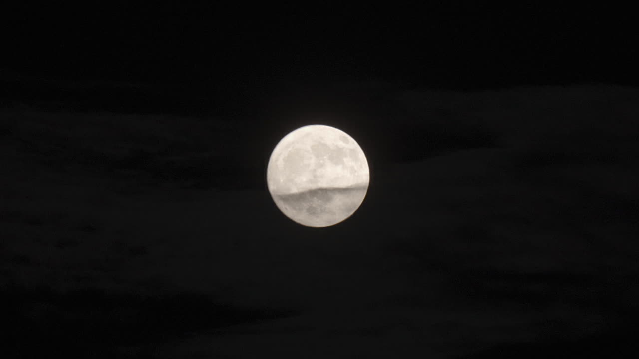 큰 보름달은 열의 진동 효과를 통해 어 ⁇ 에서 빛납니다.