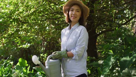 Porträt-Einer-Asiatischen-Frau,-Die-An-Einem-Sonnigen-Tag-Im-Garten-Arbeitet-Und-Lächelt