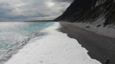 aerial drone shot of an empty remote beach and waves in taroko national park taiwan