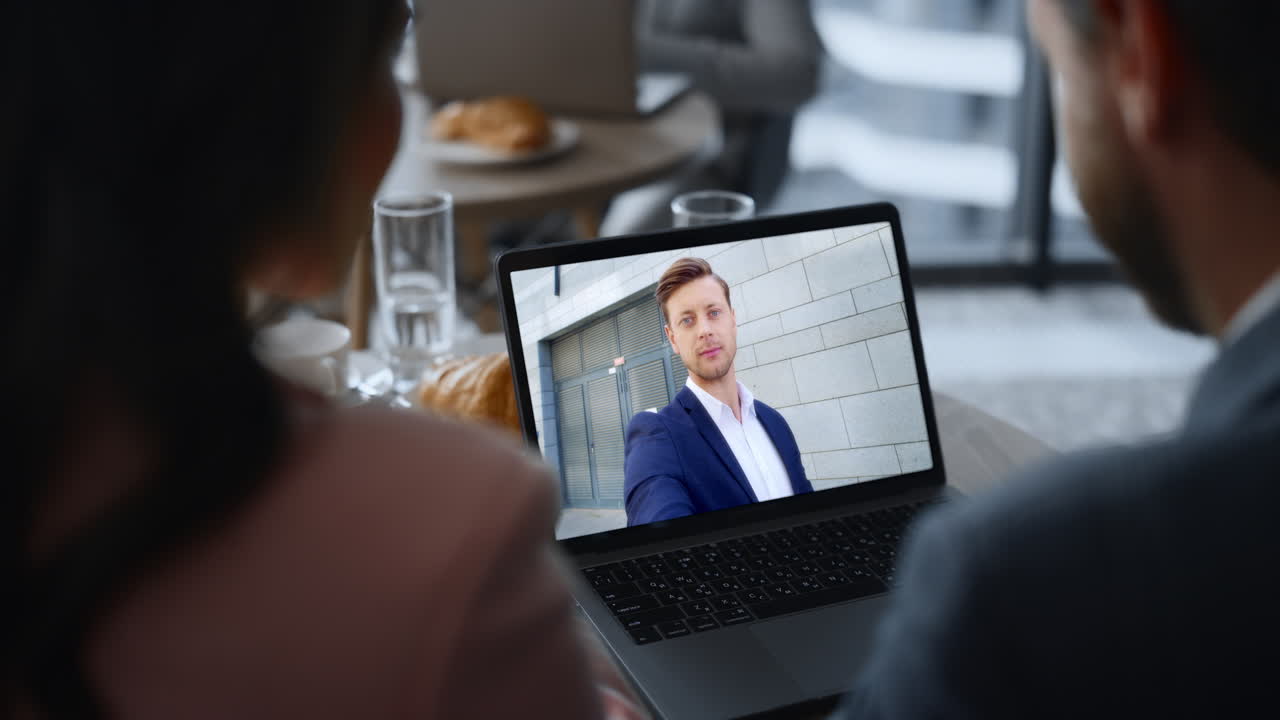 Distance worker video conferencing laptop screen with colleagues close up