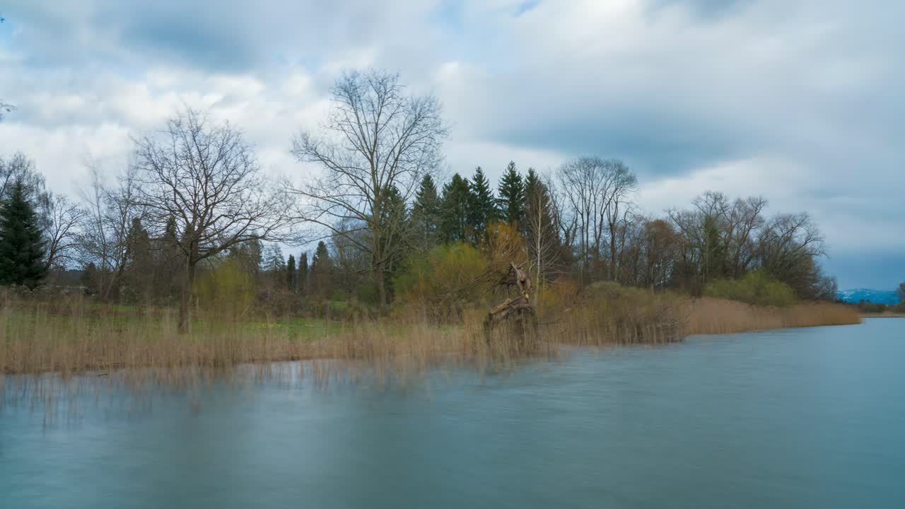 Cloudy sky moves over the lake with an island in the foreground