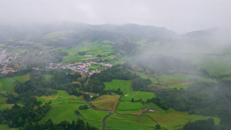 low clouds covering vegetation mountains drone view. countryside houses slopes