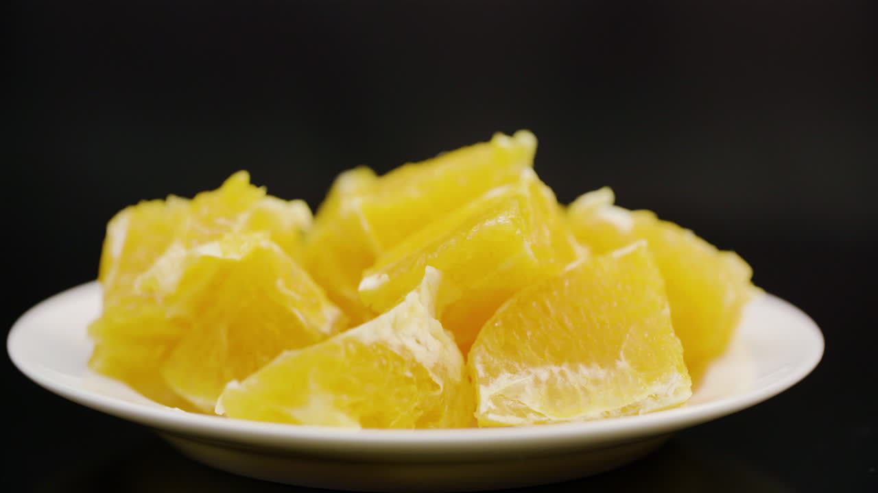 접시에 회전하는 얇게 썬 오렌지의 익스트림 클로즈업