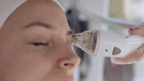 esteticista hace a la mujer rf lifting procedimiento de cosmetología de la cara y los ojos mascarilla de colágeno en el spa