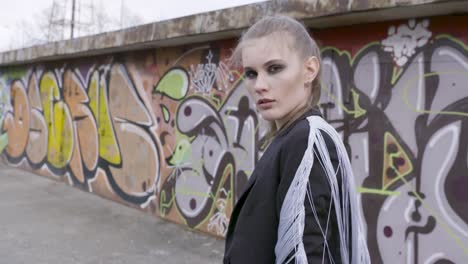 stylish woman in front of graffiti wall