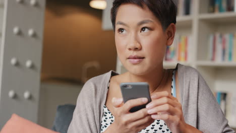 Hermosa-Mujer-Asiática-En-Casa-Usando-Internet-En-Un-Teléfono-Inteligente-Enviando-Mensajes