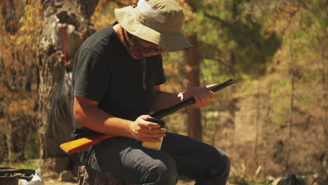 a man in camouflage reloads his shotgun while hunting in a forest for sport