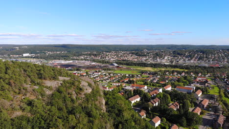 drone aéreo delantero sobre la montaña rocosa por un suburbio residencial en el este de gotemburgo, suecia, día