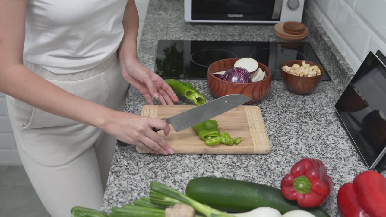 mujer cortando verduras en una cocina