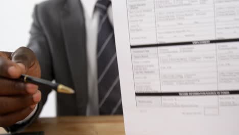 policy agent sitting at desk holding insurance contract