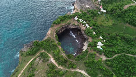 drone footage of broken beach, with blue ocean waves and rugged cliffs