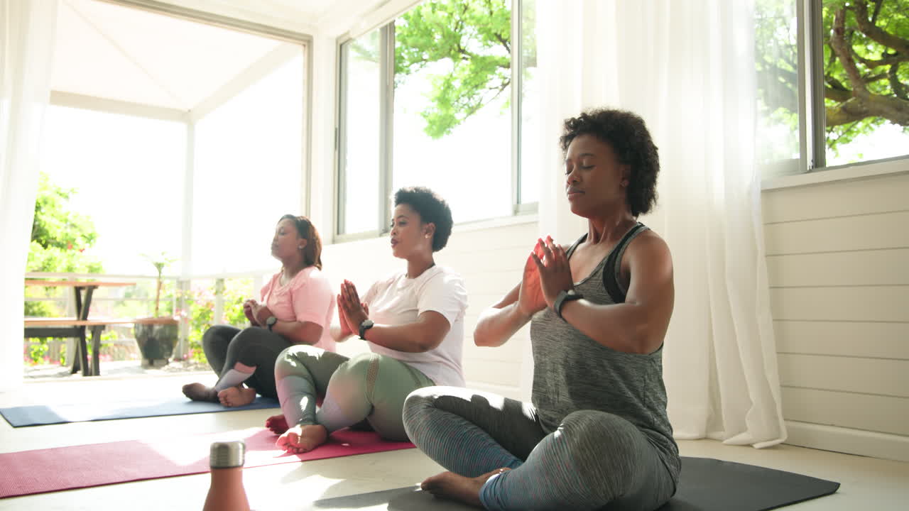 Women meditating on yoga mats, embracing tranquility and mindfulness at home