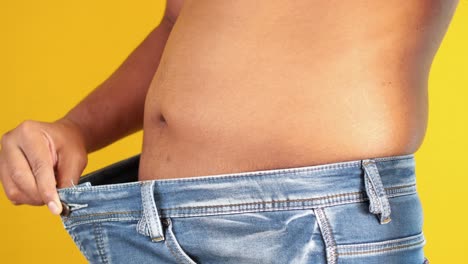 man showing weight loss with loose jeans