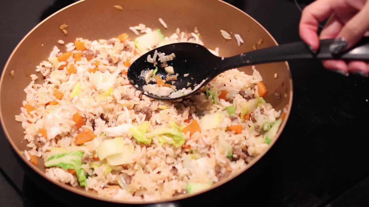 agitar y cocinar arroz frito en una estufa