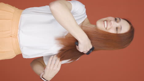 Vertical-video-of-Woman-combing-her-hair.