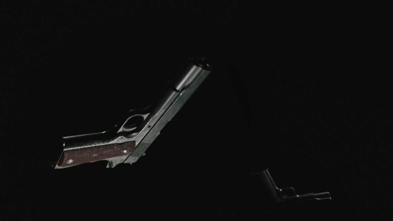 Pistols on the dark background are falling in slowmotion