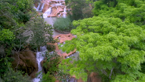 tiro de drone moviéndose a través de los árboles en las cascadas de agua azul y las cascadas encontradas en el río xanil en chiapas mexico