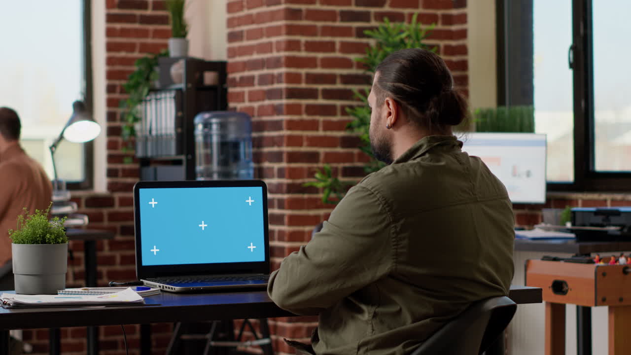 Businessman looking at greenscreen on wireless laptop