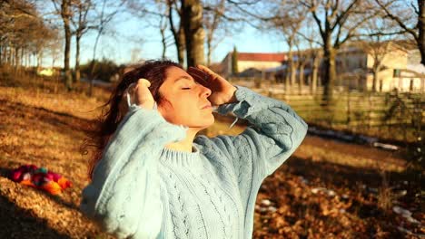 joven caucásica tocando su pelo rojo al atardecer en el bosque, tiro medio en cámara lenta