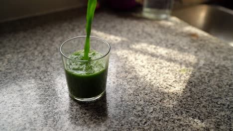 Pouring-Healthy-Green-Vegetable-Juice-Into-Glass-close